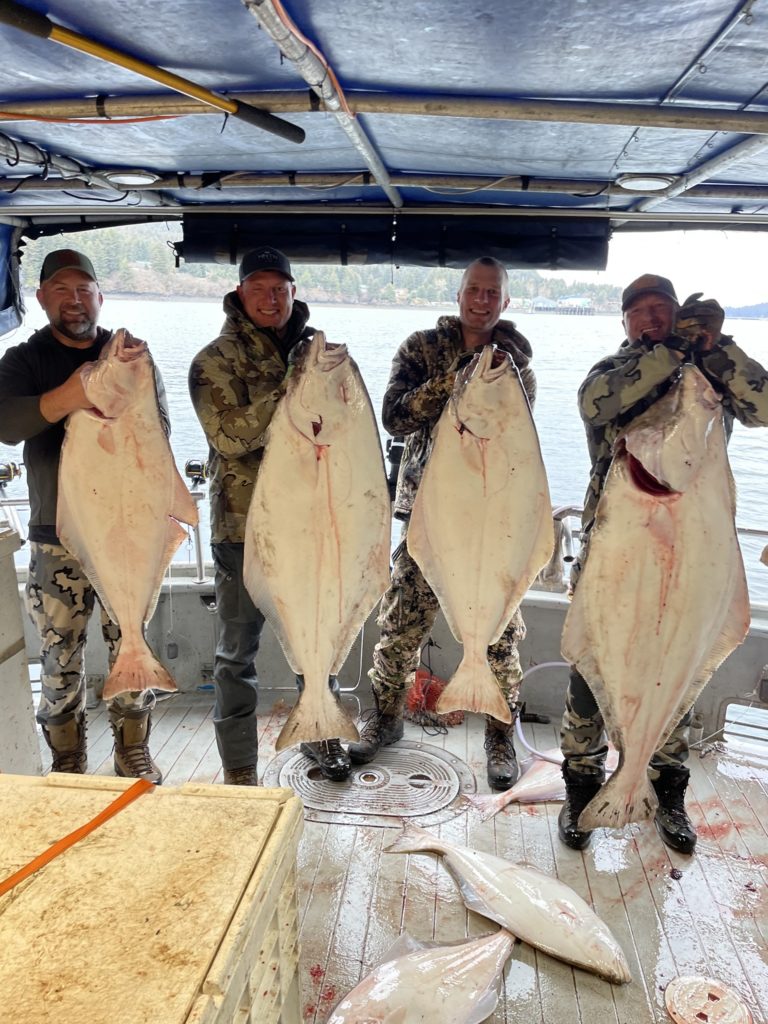 No photo description available. 4 people holding large fixh